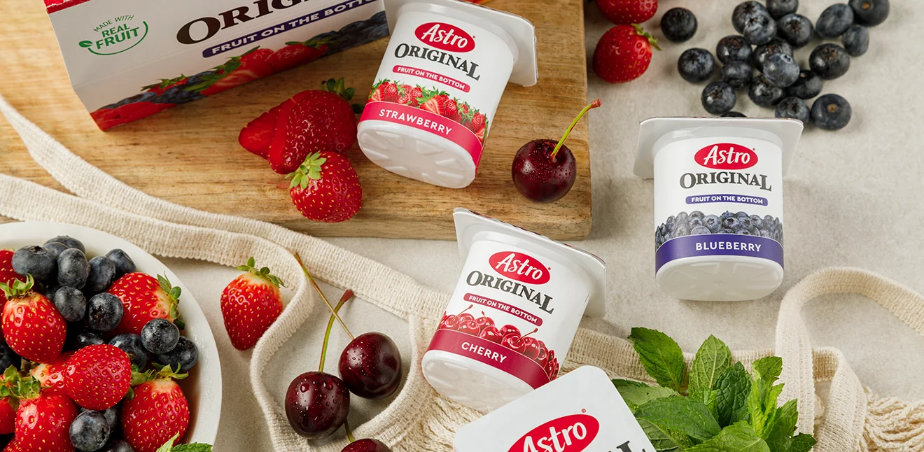 Fruit on the bottom small tubs on a table with various fruit and a bowl of fruit on a table